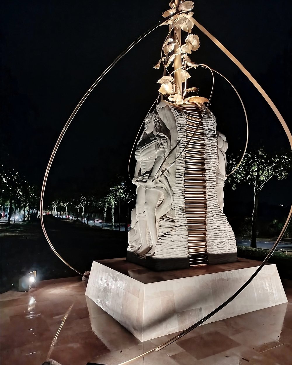 Énergie, statue monumentale en pierre et métal, éclairée de nuit
