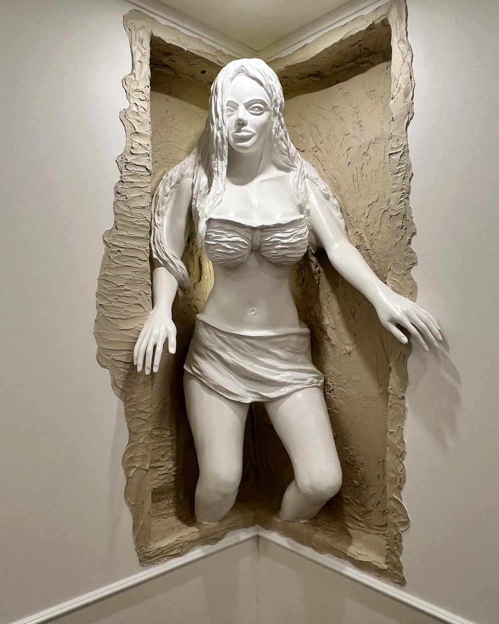 Figure de femme émergeant d'une niche murale