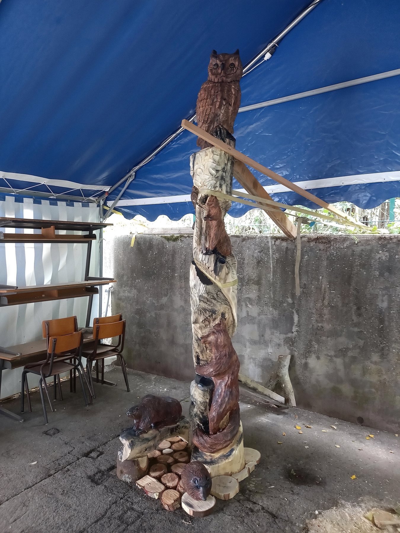 Totem de la faune des parcs en cours de réalisation, avec sa chouette, sous le chapiteau de l'atelier