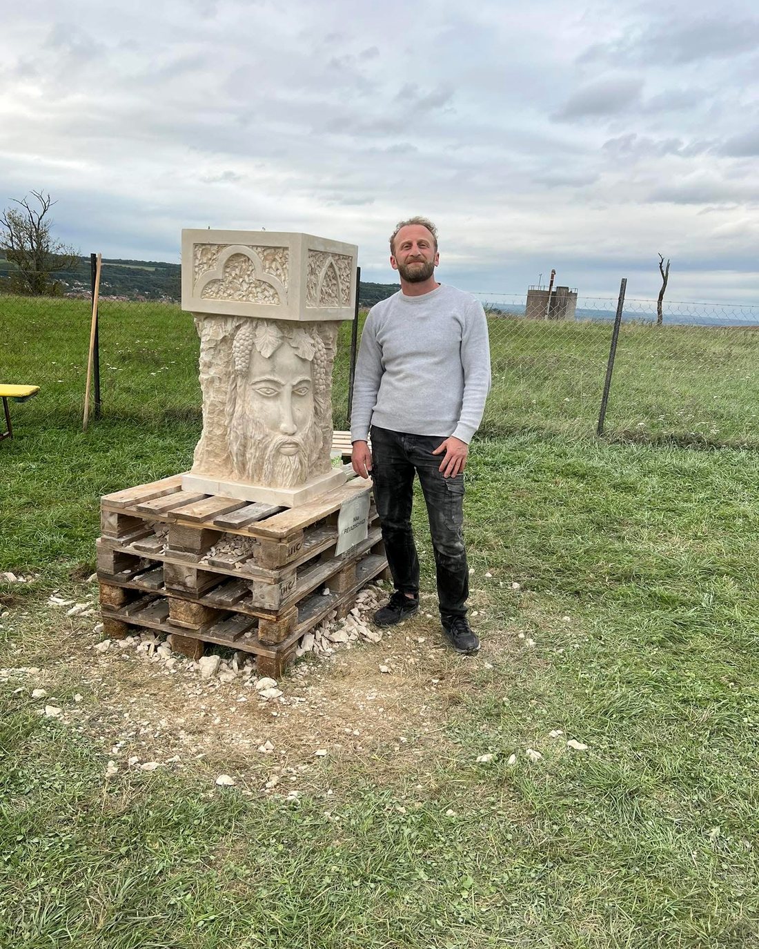 Nika devant sa stèle en pierre sculptée